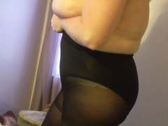 Putting on her sexp girdle over black pantyhose, big tits